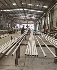 Long seamless stainless steel pipes on racks inside the Thaida workshop