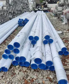 Stainless steel seamless pipes with blue end caps stacked in the yard